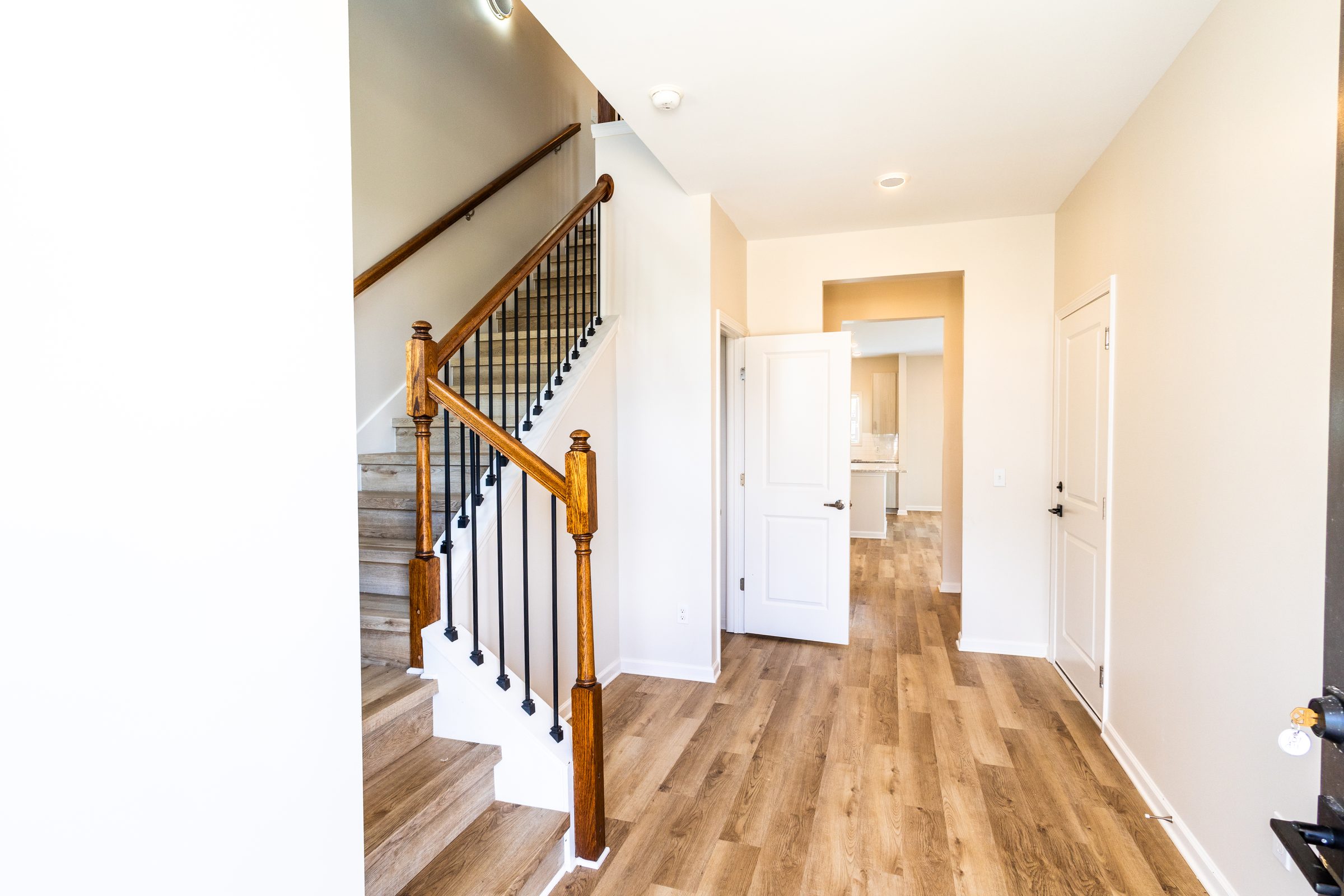 Entry foyer with wood staircase and plank flooring