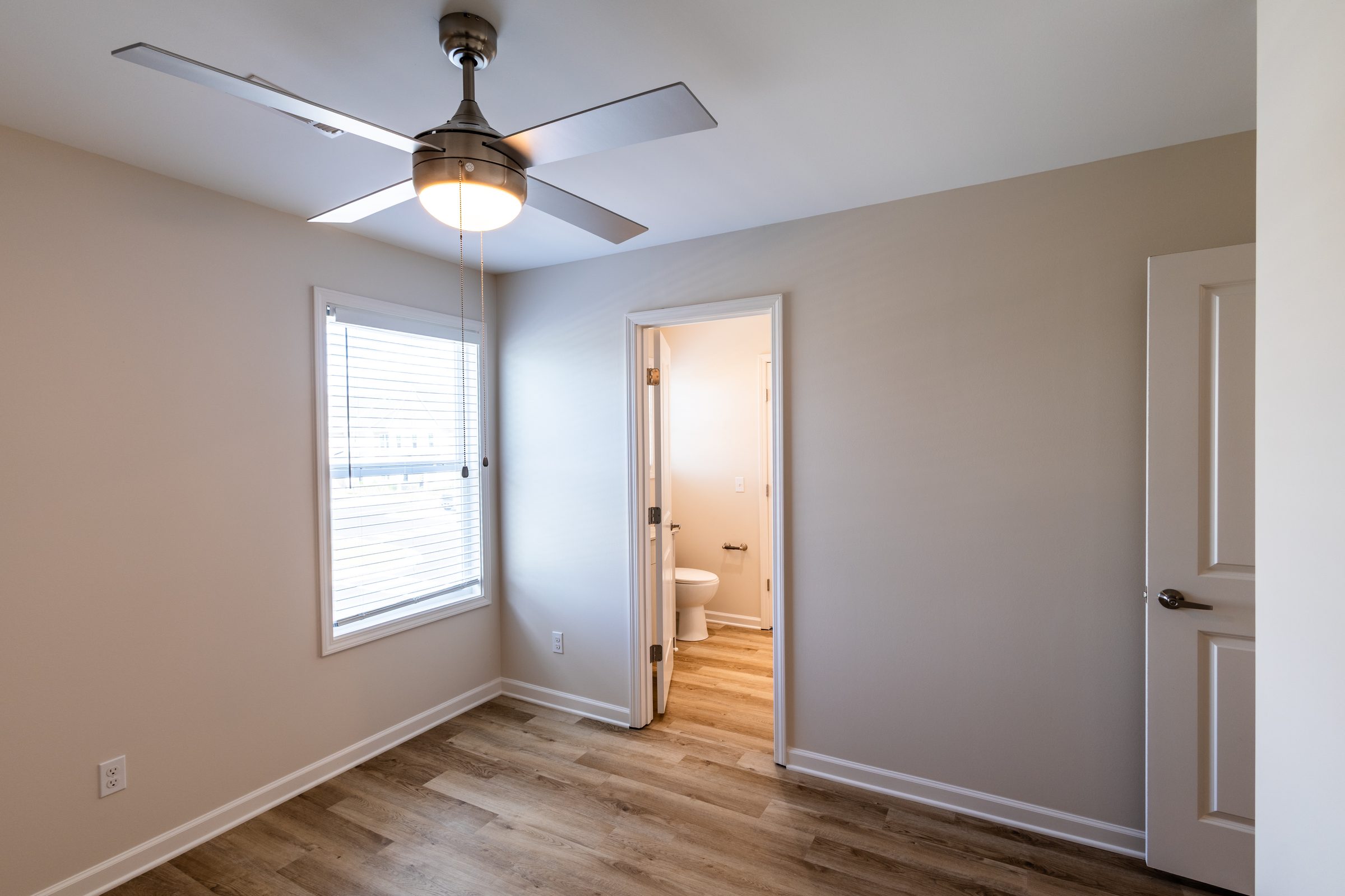 Bedroom with ceiling fan and large window